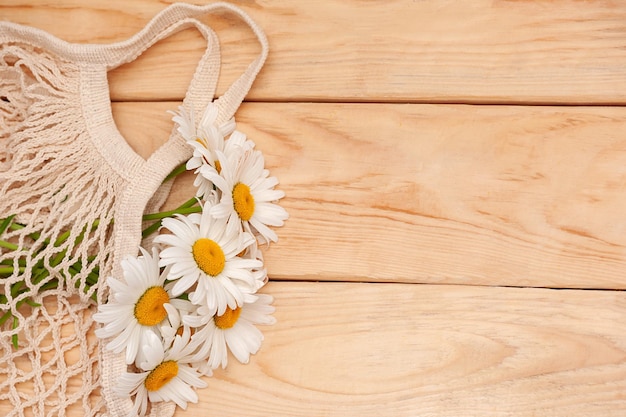 zomer achtergrond. Madeliefjes in een zak op een houten ondergrond. kopieer ruimte