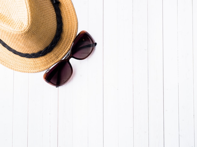 Zomer achtergrond Strohoed Armbanden Sandalen zonnebril Schelpen op een blauwe tafel