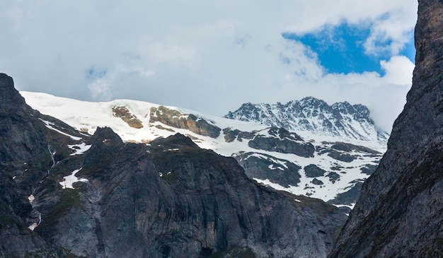 Zomer Alpen berglandschap met besneeuwde rotsachtige toppen in ver, Zwitserland.