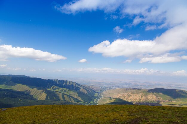 Zomer berglandschap Besneeuwde bergen en groen gras Piek Karakol Kirgizië Prachtig uitzicht vanaf de top van de berg