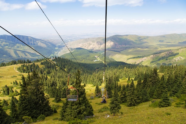 Foto zomer berglandschap hoog in de bergen hoge bomen van kerstbomen skilift bij de skibasis