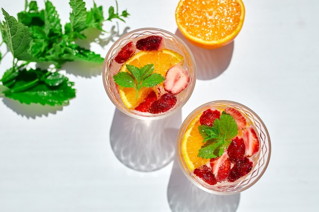 Zomer cocktail met aardbeien, sinaasappel en munt in glas