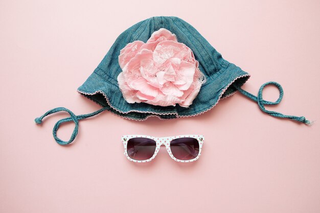 Zomer denim hoed en zonne bril op roze achtergrond