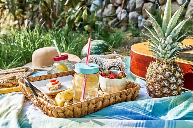 Foto zomer gezonde picknick vers tropisch fruit zoete aardbeien broodjes en verfrissend drankje