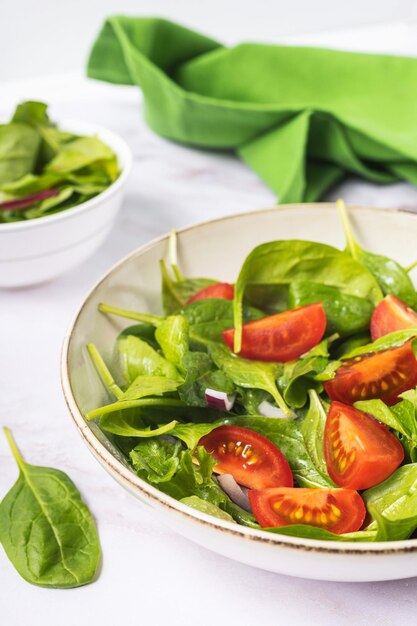 Zomer groene salade in witte kom plaat op grijze tafel