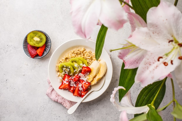 Zomer havermout met fruit en kokos in witte plaat.