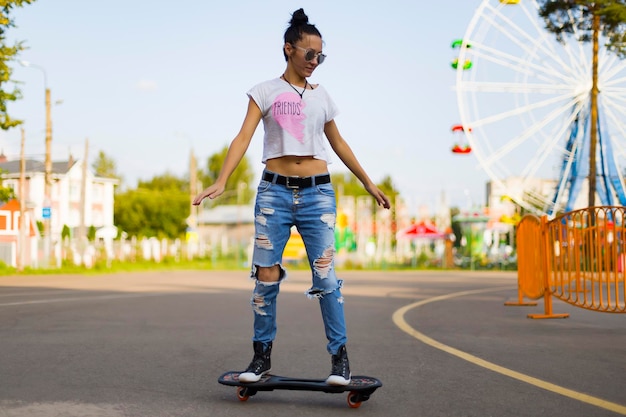 Zomer het meisje in het park op een skateboard