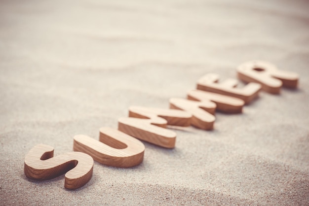 Zomer houten letters op het zand