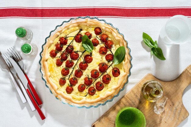 Foto zomer italiaans bladerdeeg met kerstomaatjes en ricotta op een wit tafelkleed