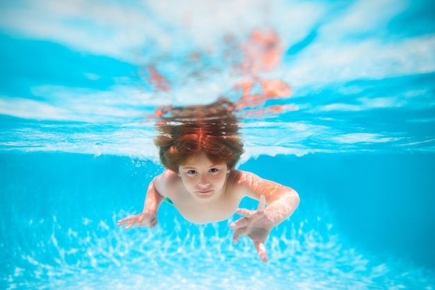 Zomer kinderen in zeewater op strand kind zwemmen in zwembad onderwater kind jongen zwemmen onder water in zee