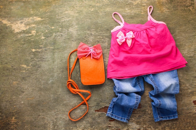 Zomer kinderkleding: t-shirt, jeans, handtas. bovenaanzicht