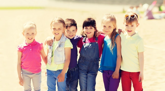 Foto zomer, kindertijd, vrije tijd, vriendschap en mensenconcept - groep gelukkige jonge geitjes op kinderspeelplaats