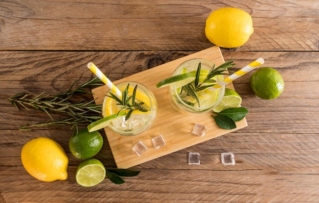 Zomer koude dranken met gesneden citrus en bruisend water in twee glazen op een houten tafelblad in rustieke stijl