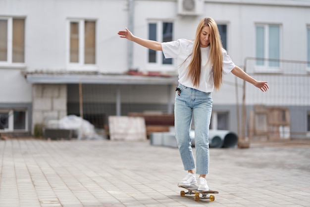 Zomer levensstijl mooi meisje leert om te rijden op een skateboard.