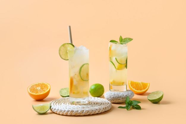 Zomer limonade of cocktail met sinaasappel en limoen schijfje op kleur achtergrond verfrissend drankje