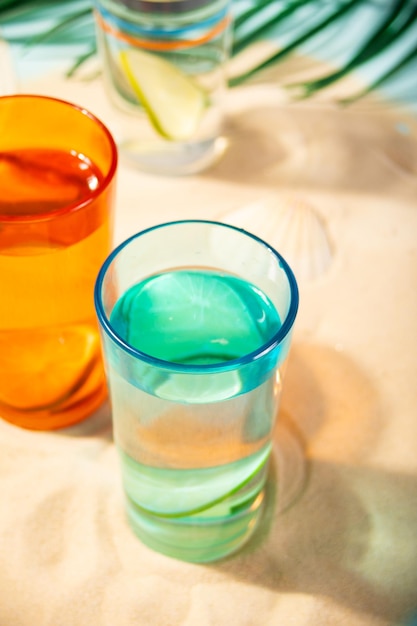 Zomer non-alcoholische cocktails in kleurrijke glazen op het strand met wit zand Zomer zee oceaan vakantie en reizen concept