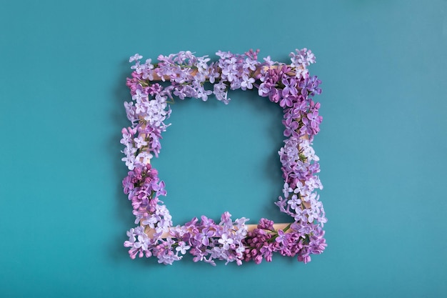 Zomer of lente compositie op een turkooizen achtergrond Lila bloemen vierkant met kopie ruimte bovenaanzicht Zomer lente bloemen concept