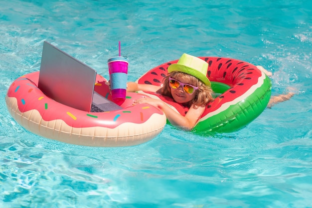 Zomer reizend kind dat op een laptop werkt bij het zwembad zomer online technologie