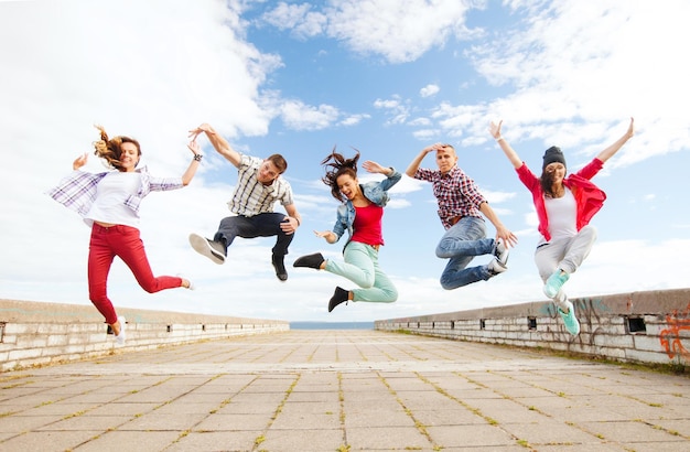 zomer, sport, dansen en tiener lifestyle concept - groep tieners springen