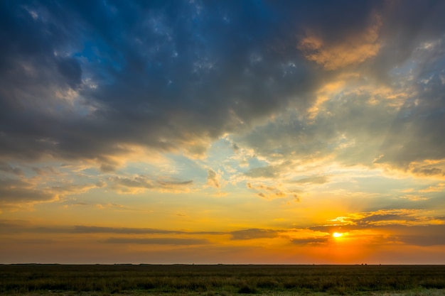 Zomer steppe. Kleurrijke zonsondergang met verlichte wolken