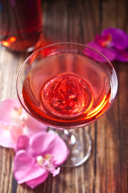 Zomer tropische roze cocktail ingericht paarse en roze orchideebloem op de houten achtergrond.