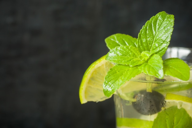 Zomer verfrissende drankjes limonade of cocktail Mojito met limoen verse munt bosbessenijs.