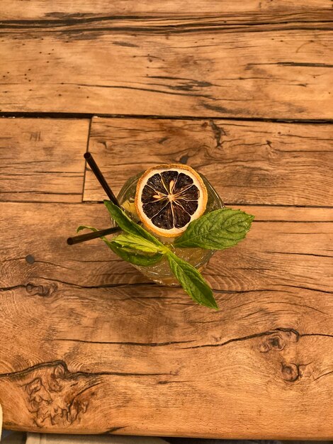 Zomer verse cocktail met gedroogde citroen en munt op de achtergrond van een houten tafel