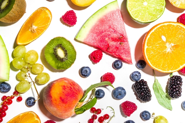 Zomer vitamine voedsel concept, diverse fruit en bessen watermeloen perzik pruim abrikozen bosbessen, plat lag op witte achtergrond bovenaanzicht kopie