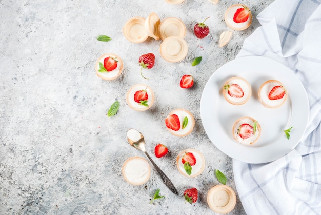 Zomer zoete zelfgemaakte dessert Mini cheesecakes met aardbei op grijze stenen tafel