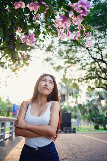 Zomer zonnige levensstijl portret van jonge stijlvolle hipster vrouw lopen op straat met schattige trendy outfit jonge aziatische vrouwelijke toeristische reiziger glimlachend in bangkok straatmode