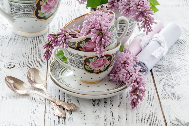 Zomerbloeiende boeket van lila en porseleinen kopje met zwarte thee