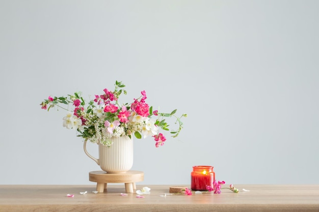 zomerbloemen en brandende kaarsen op lichte achtergrond