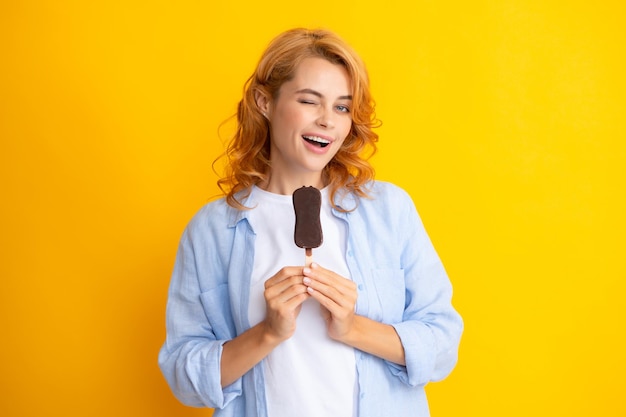 Zomerconcept Winks vrouw houdt lekker bevroren ijs en geniet van het eten van heerlijke koude desserthoudingen