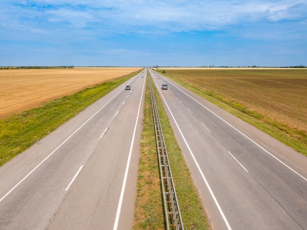 Zomerdag. Een vogelvlucht van een landweg in het veldlandschap. Luchtfoto