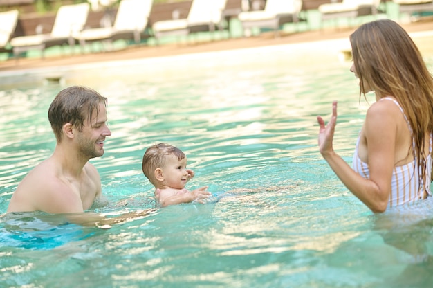 Zomerdagen. Een jong gezin dat tijd doorbrengt in een zomerzwembad