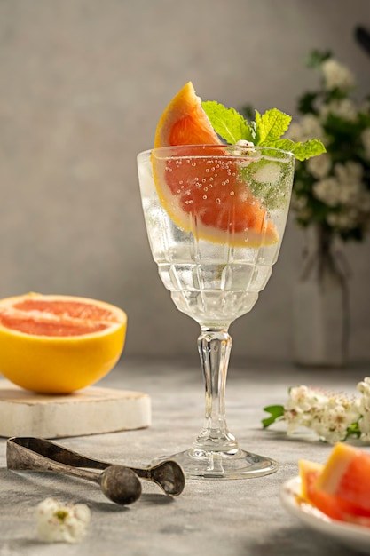 Zomerdrankje met grapefruit in fancy glas en bloeiende brunch op achtergrond