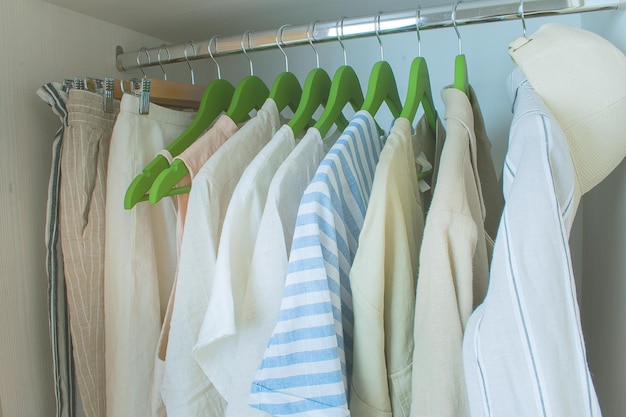 Zomergarderobe met linnen kleding aan groene hangers