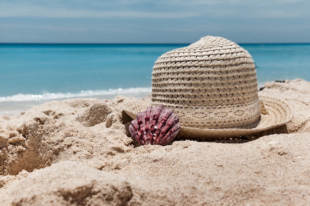 Zomerhoed op het zandstrand met blauwe zee