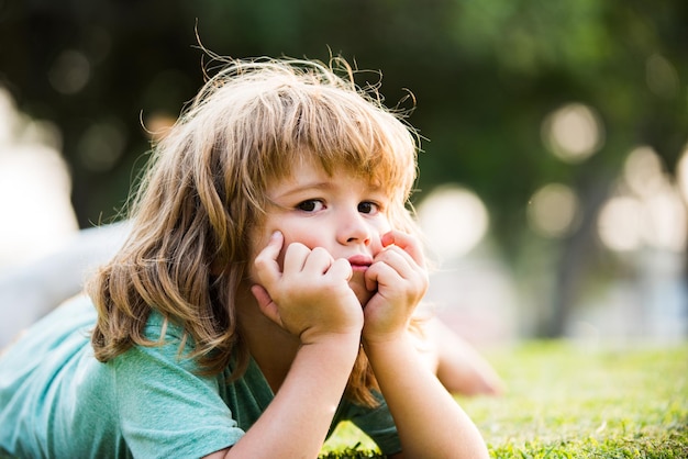 Zomerkinderen dromen buitenportret gelukkig kind genietend op het grasveld en dromende kinderen op groene gr