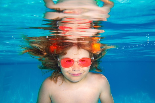 Zomerkinderen worden geconfronteerd met onderwaterkind zwemt in zwembad gezond kind zwemmen en plezier maken onder water