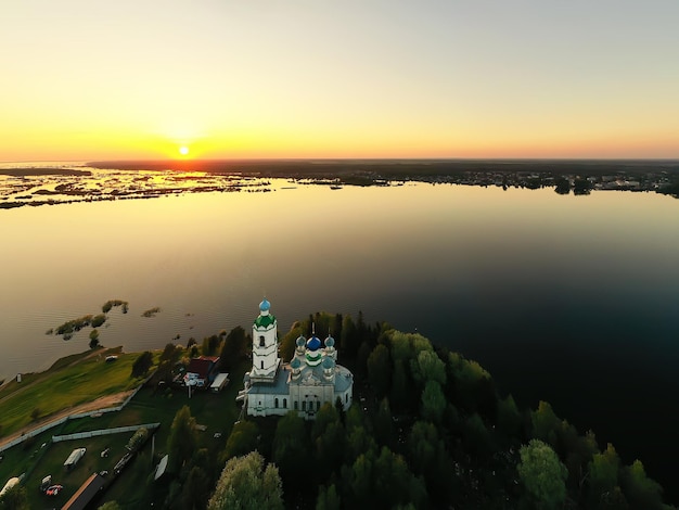 zomerlandschap in rusland zonsondergang, kerk aan de oevers van de rivier christendom orthodoxie