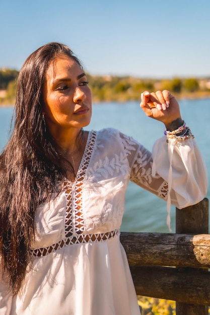 Zomerlevensstijl een jonge Latijnse brunette die geniet van een park in een witte jurk