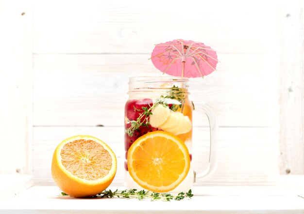 Zomerlimonade met fruit en bessen in een potje