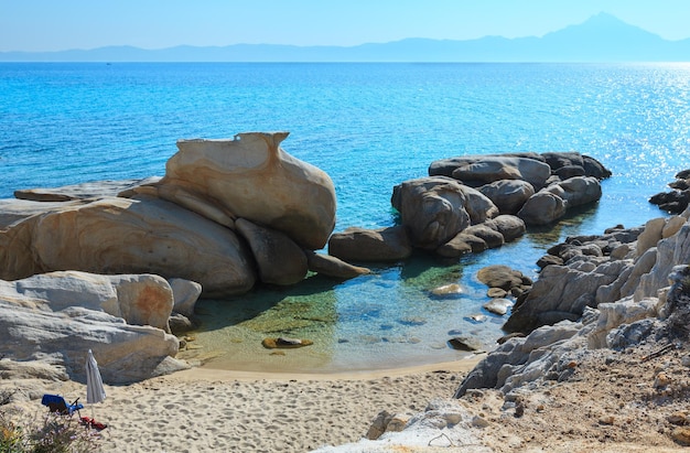 Zomerochtend zandstrand en rotsachtige kust in de buurt van Platanitsi Beach (schiereiland Sithonia, Chalcidice, Griekenland).