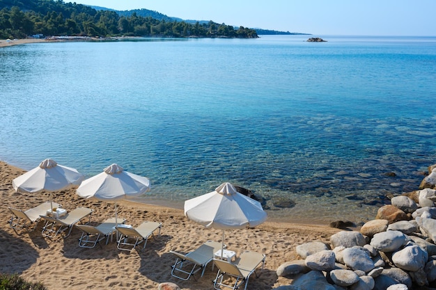 Zomerochtend zandstrand met ligbedden en parasols (Sithonia, Chalkidiki, Griekenland).