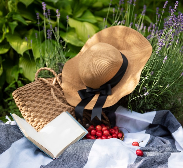 Zomerpicknick in lavendelveld. Stilleven zomer buiten picknick met bessen, strohoed en boek