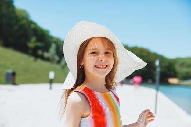 Zomerportret van een klein meisje buiten op het strand zomervakantiemeisje in een hoed