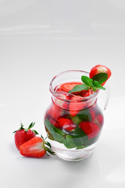 Zomers met vers fruit gearomatiseerd water van aardbei en munt. Ruimte voor test of ontwerp.