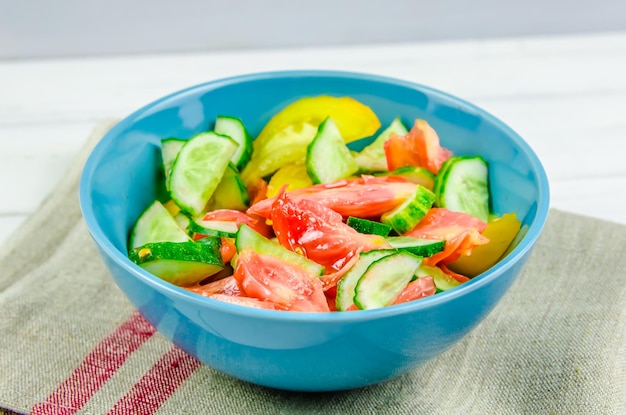 Zomersalade met komkommers en tomaten op witte achtergrond