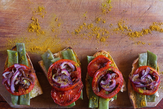 Zomersandwich bereid met gebakken rode ui, tomaat en bruine bonen